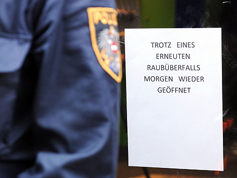 Polizist vor Schild "Morgen wieder geöffnet" nach Überfall auf Juwelier beim Hotel Hilton in Wien-Landstraße