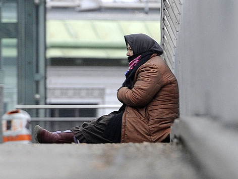 Frau bettelt auf einer Brücke in Wien-Hütteldorf