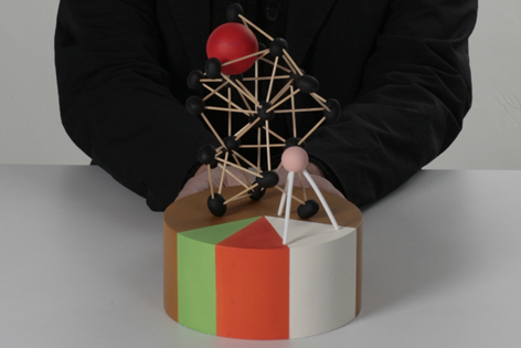 Buntes Modell mit kleinem Holzgerüst und rotem Ball