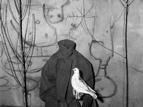 Fotografie von Roger Ballen: Eine Person ohne Kopf hält eine Taube