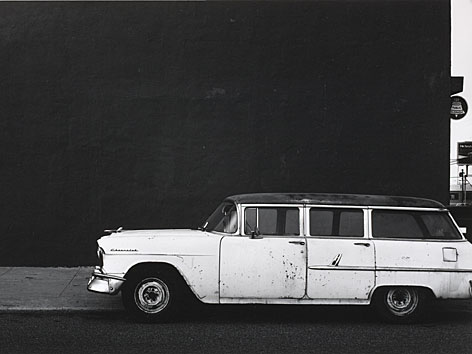 Foto von Lewis Baltz, dass ein weißes Auto vor einer kargen Wand zeigt