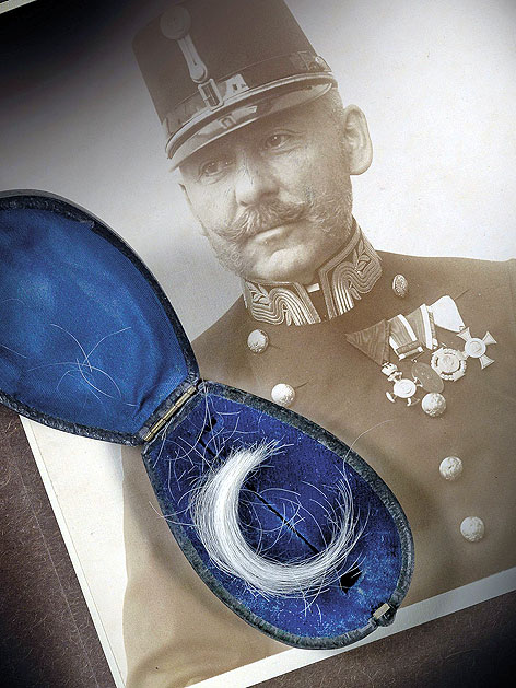 Haarlocke Kaiser Franz Jospehs, aufbewahrt in einem dunkelblauen Samtetui und eine Fotografie des kaiserlichen Leibkammerdieners Eugen Ketterl vor Auktion im Dorotheum