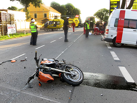 Einsatzkräfte der Rettung und Polizei am Mittwoch, 3. Juli 2013, bei Bergungsarbeiten an der Unfallstelle nachdem ein Biker mit einem Pkw auf der Brünner Straße in Floridsdorf kollidierte.