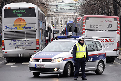 Polizist vor parkenden Busse auf der Ringstraße