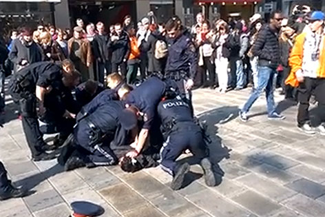 Polizisten knien auf Mann