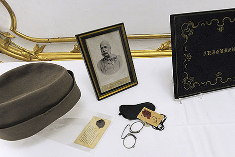 Hauskappe, eine Porträtfotografie (um 1898) und ein Zwicker (Metallrahmen in Lederetui mit Beglaubigung des Leibkammerdieners Ludwig Egger) von Kaiser Franz Joseph