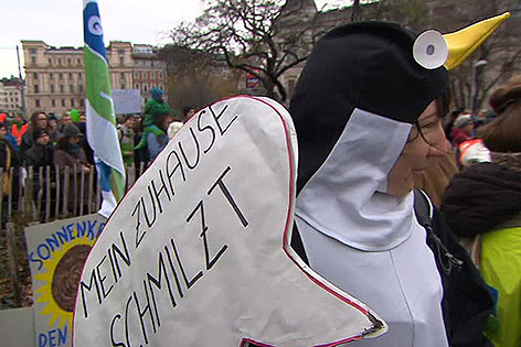 Frau in Pinguin-Kostüm bei Demo