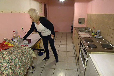 Frau in Küche einer Gemeindewohnung
