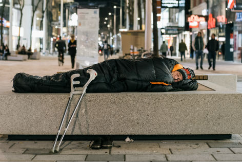 Obdachloser schläft auf Bank