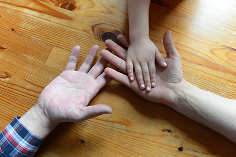 Hände eines homosexuellen Paares und eines Kindes.