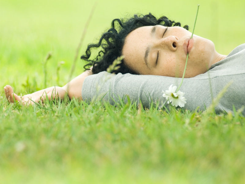 Frau liegt entspannt im Gras