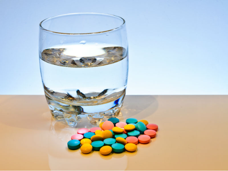 Tabletten und Wasserglas