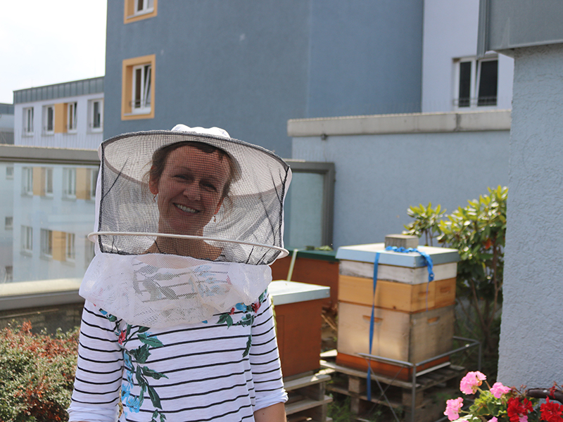 Imkerin vor Bienenstöcken